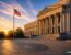State government administrative building facade at sunrise with warm golden light on limestone columns, empty stone plaza in cool morning shadow — trucking state filings guide Form E Form H BMC-91 SR-22 by Ensure Inc., Barrington IL insurance agency